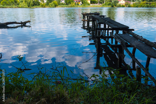 Wooden ruined old pier on the river bank photo