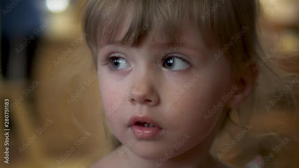 Little girl looks at the camera close-up Little girl looks at the camera close-up