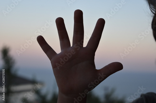 isolated children hands show the number five. silhouette of finger in low light