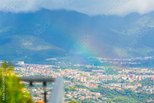 A little rain falls on the city of San CRistobal during the afternoon and a rainbow appears photo