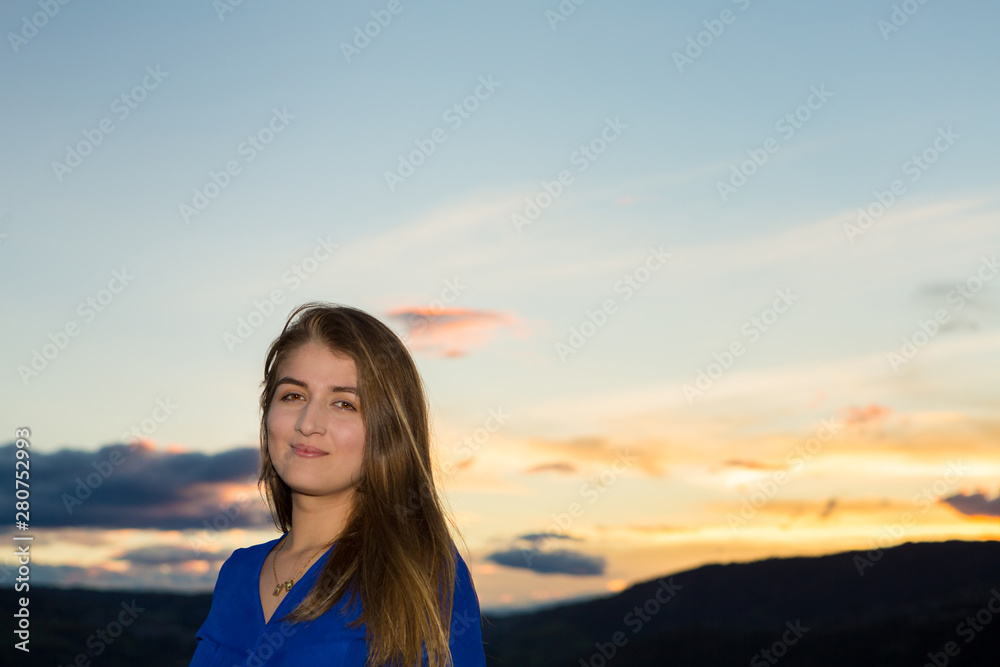 Young poses for portrait with nature during sunset.