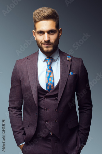 Stylish young man in suit and tie. Business style. Fashionable image. Office worker. Sexy man standing and looking at the camera