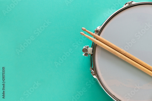 Murais de parede Drum and drum stick on green table background, top view, music concept
