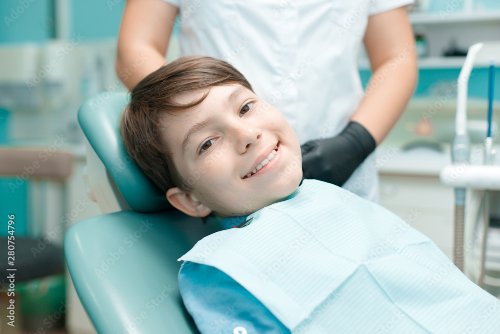 Little boy in dental chair. Smiling and satisfied patient at dentist's office after treatment. Healthy teeth, dental care concept. Little boy in dental chair. Smiling and satisfied patient at dentist's office after treatment. Healthy teeth, dental care concept.