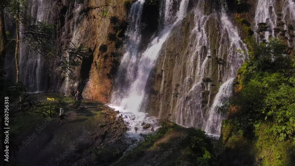Man and woman together walks in canyon along the river through the waterfall Tumpak Sewu and Goa Tetes, Java island, Indonesia Man and woman together walks in canyon along the river through the waterfall Tumpak Sewu and Goa Tetes, Java island, Indonesia