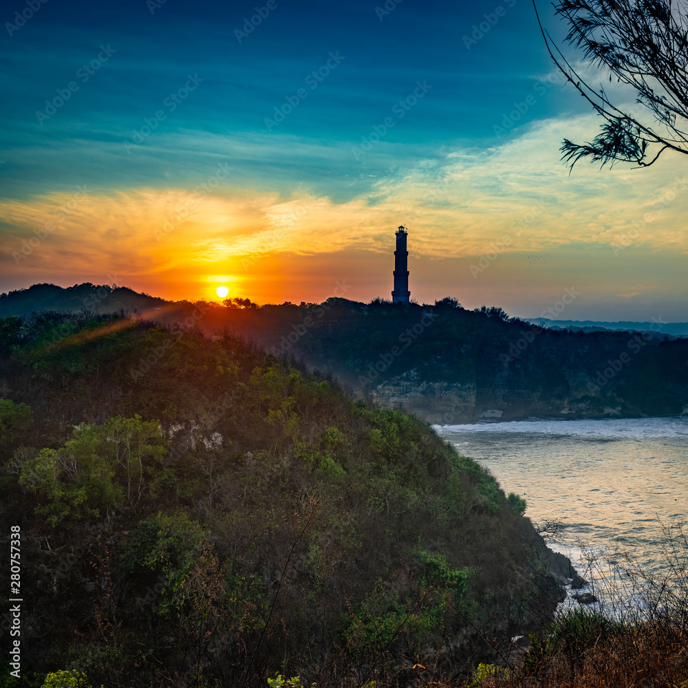 Lighthouse silhouette landscape view in sunrise golden sky