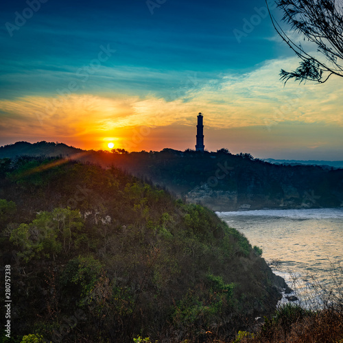 Lighthouse silhouette landscape view in sunrise golden sky