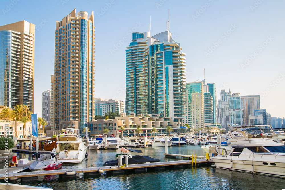 Dubai, UAE United Arabs Emirates. Dubai marina skyscrapers and yachts at sunset. Apartments, hotels and office buildings, modern residential development of UAE