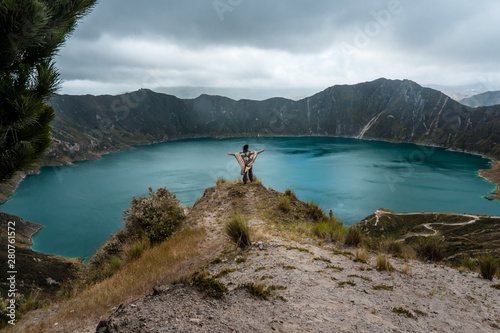 Person in blue lake and trees, Quilotoa lake in Ecuador