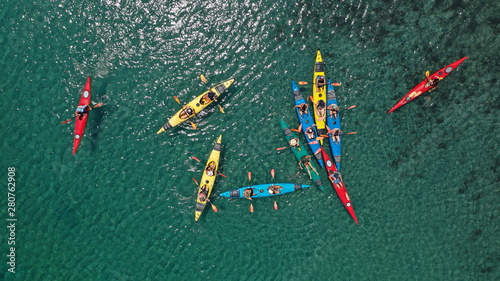 Aerial drone photo of colourful sport canoes operated by young athletes competing in Mediterranean bay with crystal clear turquoise sea