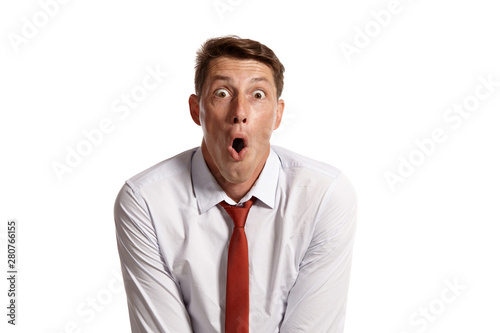 Portrait of a young brunet man posing in a studio isolated over a white background.