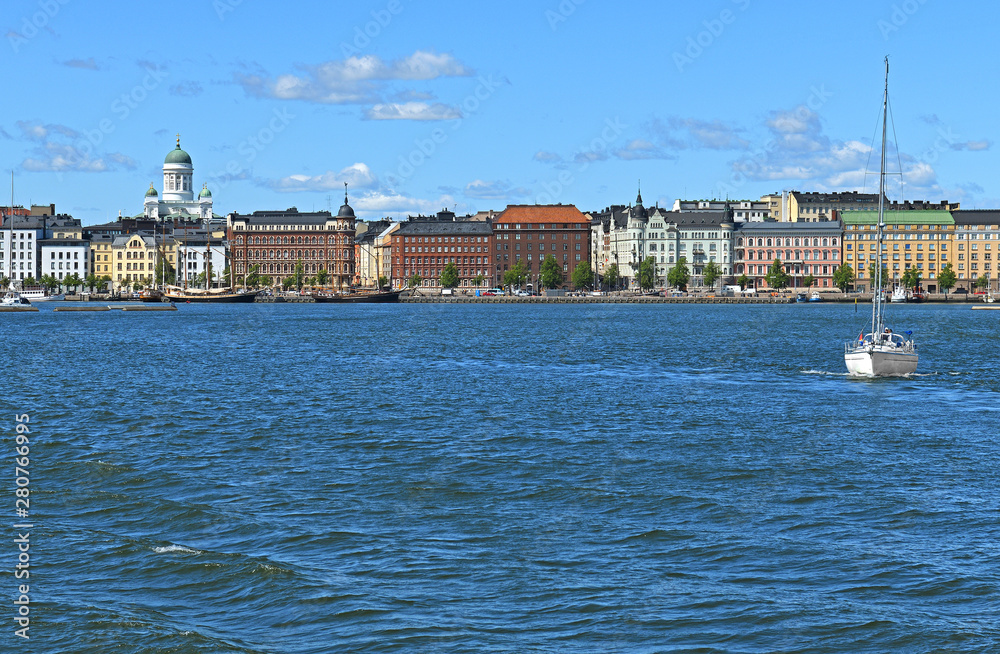 Pohjoisranta embankment, harbor with yacht on background of Finnish Evangelical Lutheran cathedral of Diocese. Helsinki, Finland