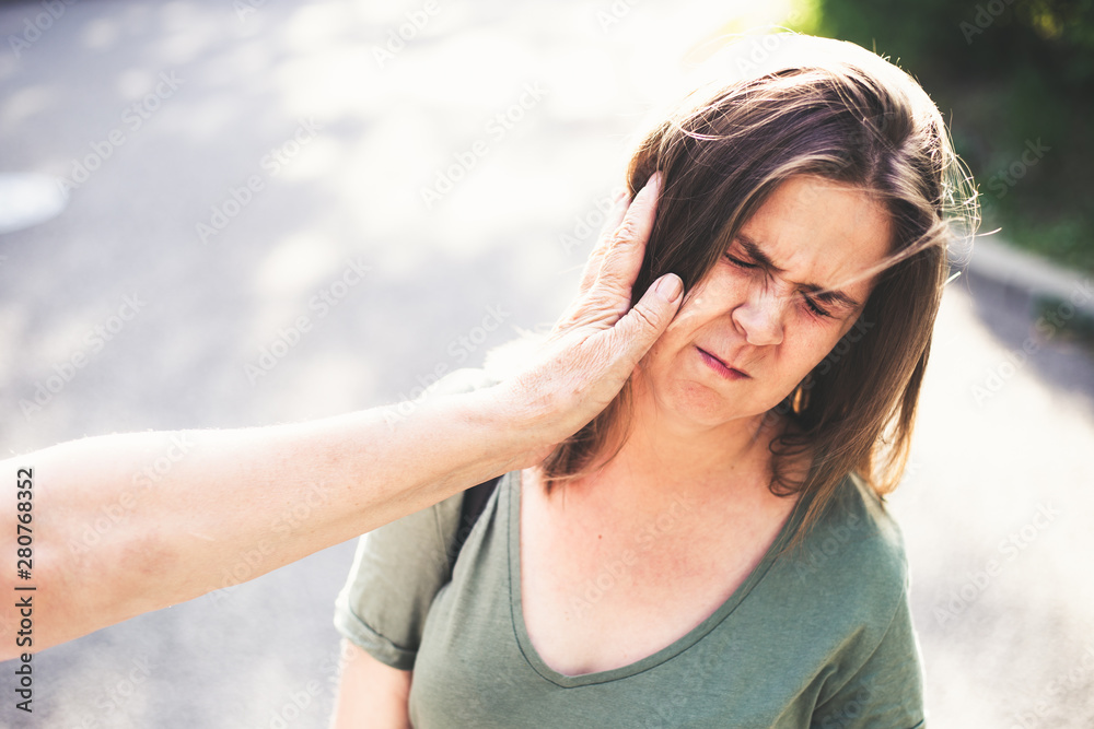 Grandmother slapping niece on the street in daylight – Outdoor cruel abuse in public – Social issue concept Grandmother slapping niece on the street in daylight – Outdoor cruel abuse in public – Social issue concept