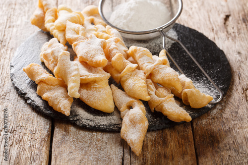 Polish dessert faworki with powdered sugar close-up. horizontal photo