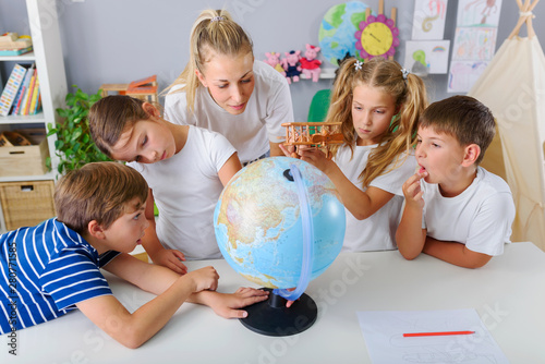 Obraz na plátne Teacher with School Children Making Geography Lessons Fun and Interesting