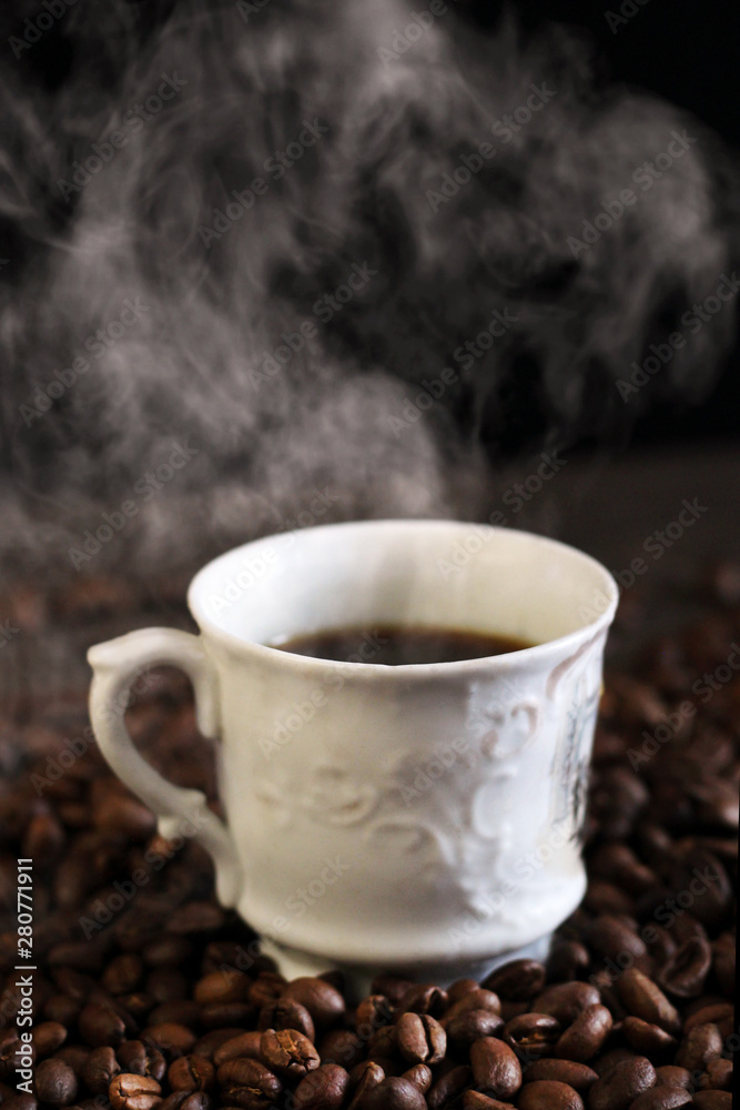 Black coffee in white cup with steam and coffee beans Black coffee in white cup with steam and coffee beans