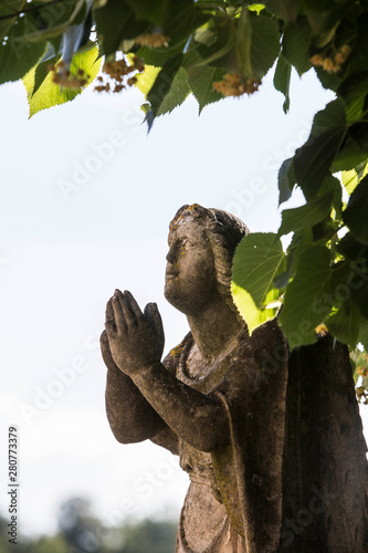 statua raffigurante una donna che sta pregando photo