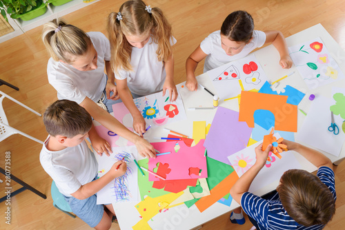 Mother or school teacher with children. Creative arts and crafts project at school or at home. photo