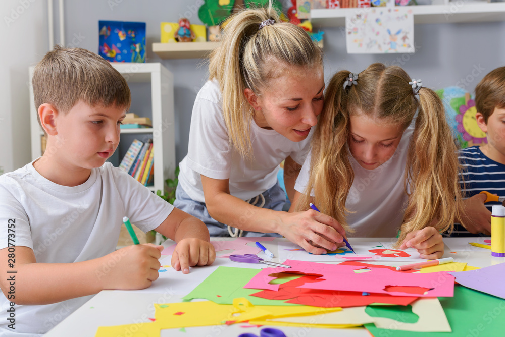 Mother or school teacher with children. Creative arts and crafts project at school or at home. Mother or school teacher with children. Creative arts and crafts project at school or at home.