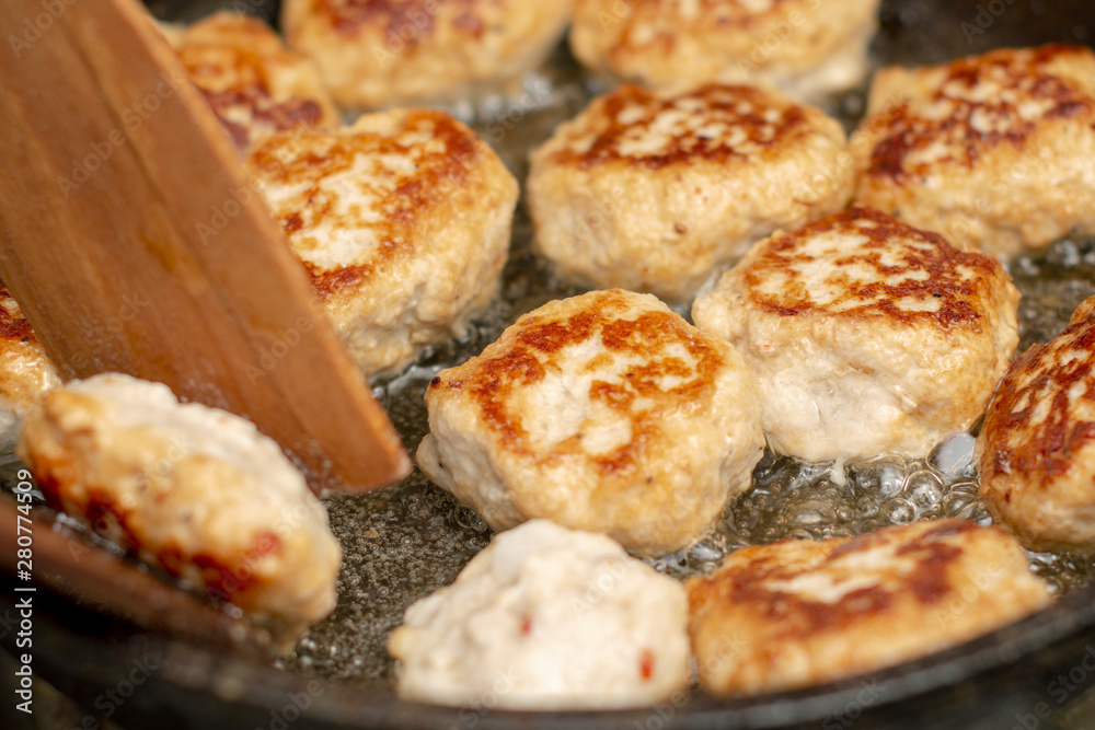 Tasty, fragrant healthy cutlets of chicken meat with spices are fried in a pan in oil.
