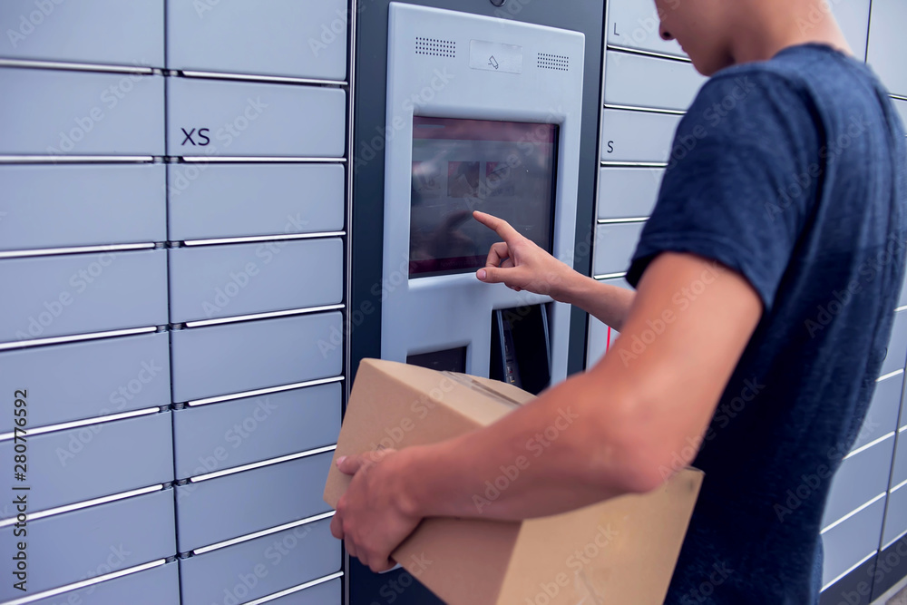 Fotografie, Obraz Client using automated self service post terminal machine or locker to deposit a