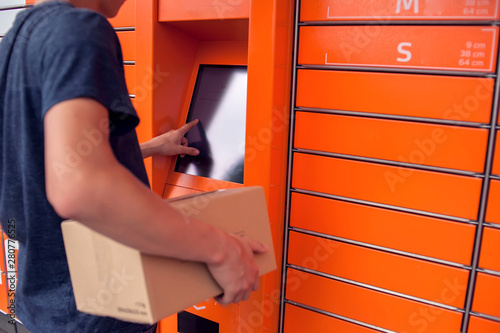 Client using automated self service post terminal machine or locker to deposit a parcel for storage