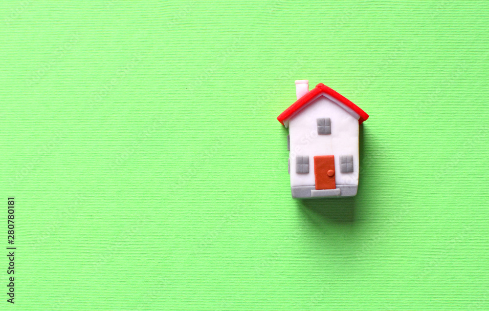 Dream about own house concept with miniature toy house with red roof on a green background. Dream about own house concept with miniature toy house with red roof on a green background.