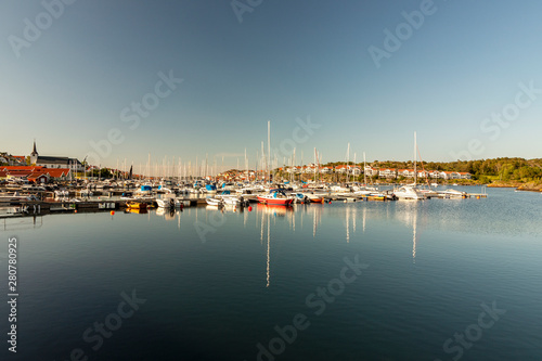 Sailboats moored in harbor against clear sky