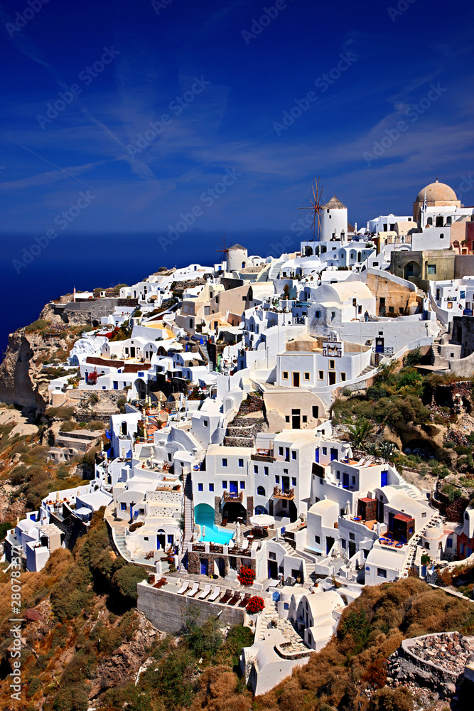 SANTORINI ISLAND, CYCLADES, GREECE . The west part of Oia village, with its famous windmills, hanging over the caldera.
