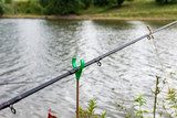 Fishing rod with a bell in the water, fishing in summer
