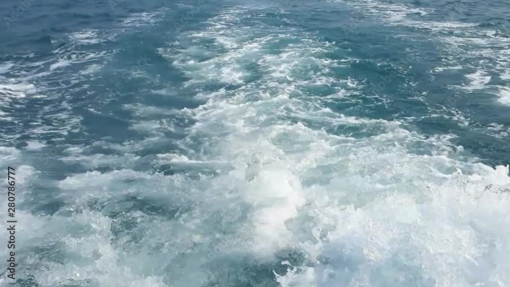 Close up powerful waves pulled out from fast moving boat. Water foam trace behind the ship. Close up powerful waves pulled out from fast moving boat. Water foam trace behind the ship.