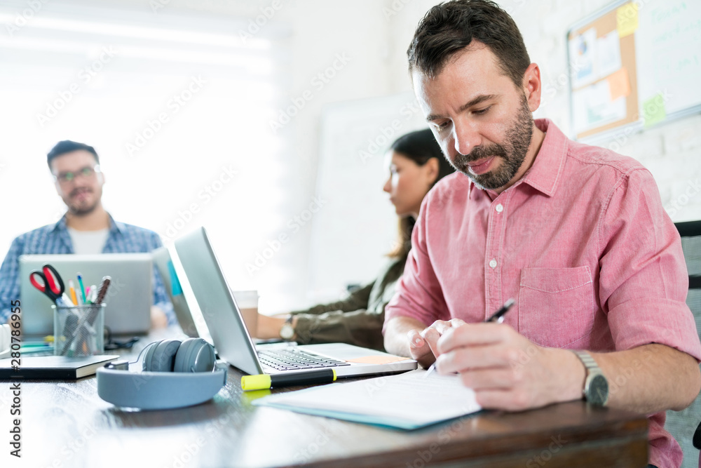 Male Executive Writing Ideas On Paper At Office Male Executive Writing Ideas On Paper At Office