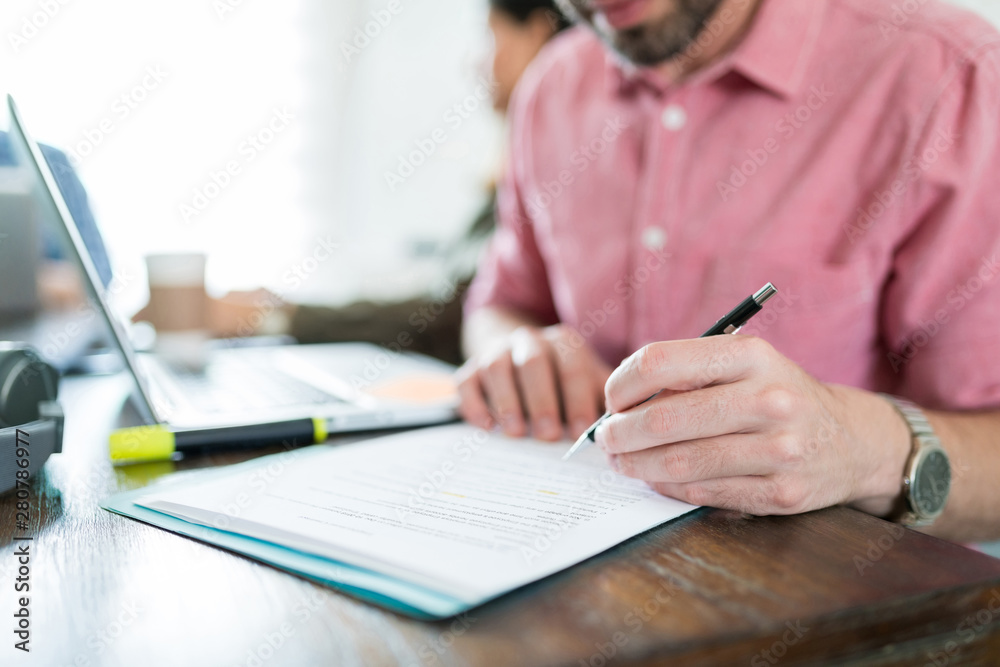 Male Entrepreneur Signing Document At Office Male Entrepreneur Signing Document At Office