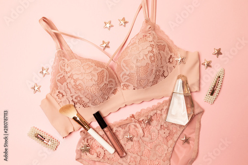 Woman elegant pink lace bra and panties, jewelry. Stylish lingerie flat lay.