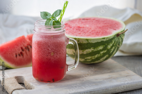 Photo of watermelon smoothie in jar with straw on light background. Fresh organic Smoothie. Health or detox diet food concept.