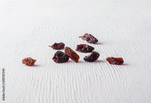 A variety of peeled walnuts and raisins on a white wooden background. View from above. Plenty of space for text.