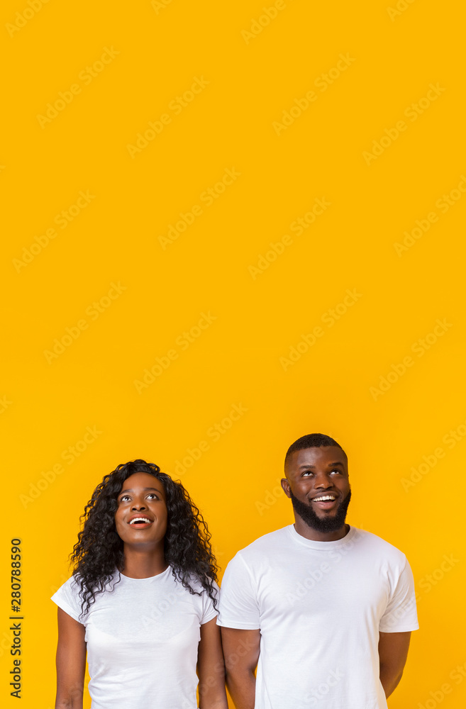 Fototapeta premium Amazed african american man and woman looking upwards