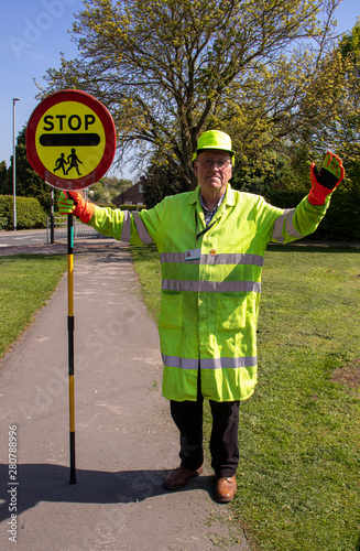 A pensioner employed as a road traffic patrolman about to supervise a busy crossing point