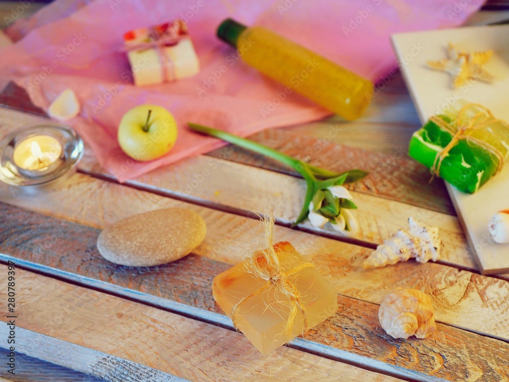 Natural soap, lighted candles, flower, sea stones and shells on a wooden table, spa procedures, body care, healthy lifestyle Natural soap, lighted candles, flower, sea stones and shells on a wooden table, spa procedures, body care, healthy lifestyle