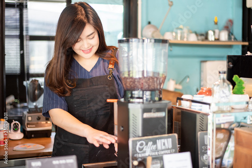 Beautiful barista is smiling in her coffee shop