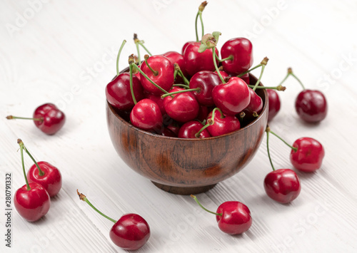 .sweet cherries in a plate on a wooden white background