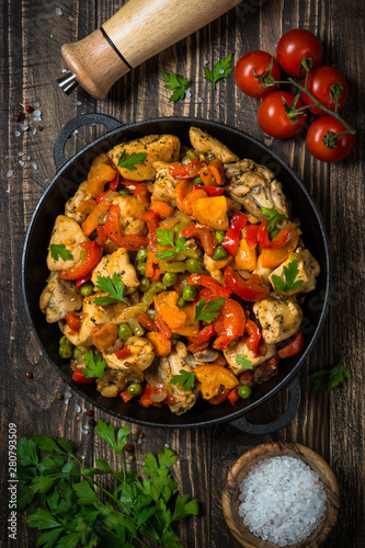 Chicken Stir fry with vegetables on wooden table.