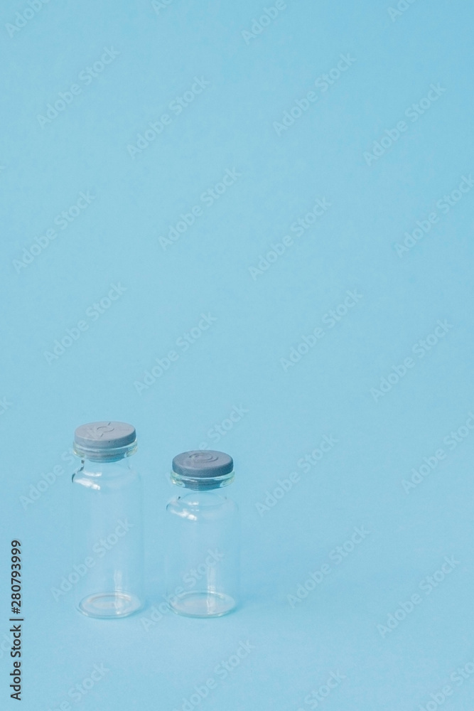 Vial of medicine on blue background with copy space. Antibiotic or vaccine medication. Healthcare and pharmacy innovations Vial of medicine on blue background with copy space. Antibiotic or vaccine medication. Healthcare and pharmacy innovations