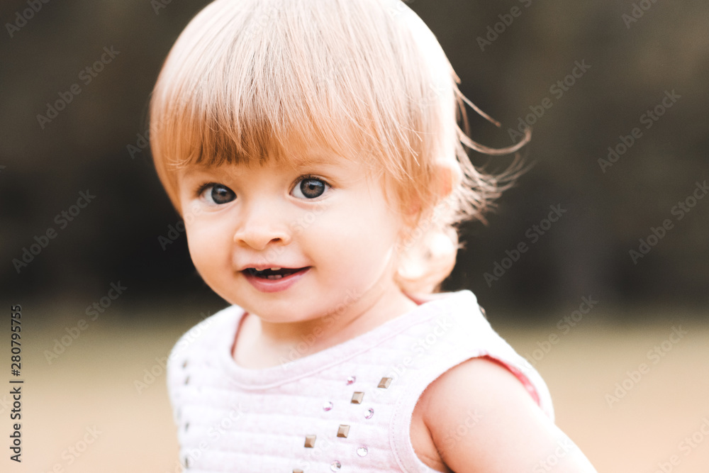 Happy baby girl 1-2 year old outdoors closeup. Looking at camera. Stock  Photo | Adobe Stock