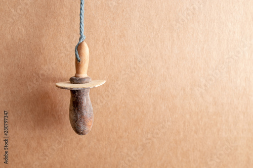 Old baby dummy from the 19th century hanging from a string photo