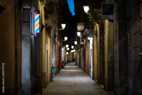 Blurred downtown alley at night with barbershop or hairdresser's sign on the wall © Gabriel
