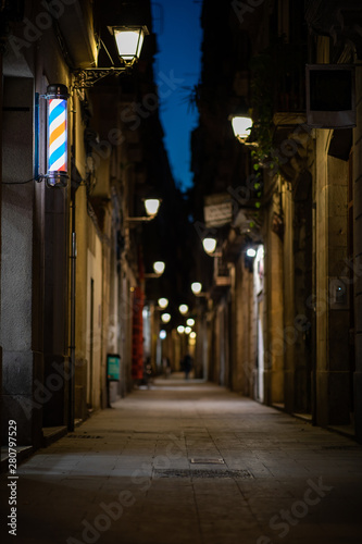 Blurred downtown alley at night with barbershop or hairdresser's sign on the wall © Gabriel