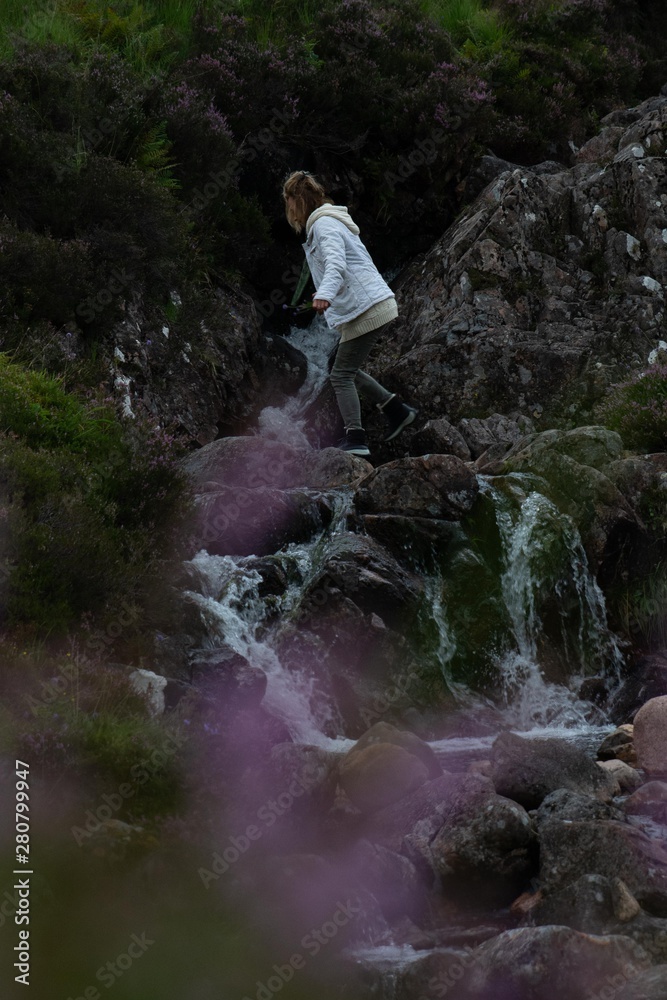 Woman walking in a stream in Scotland Woman walking in a stream in Scotland