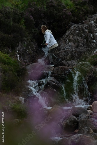 Woman walking in a stream in Scotland