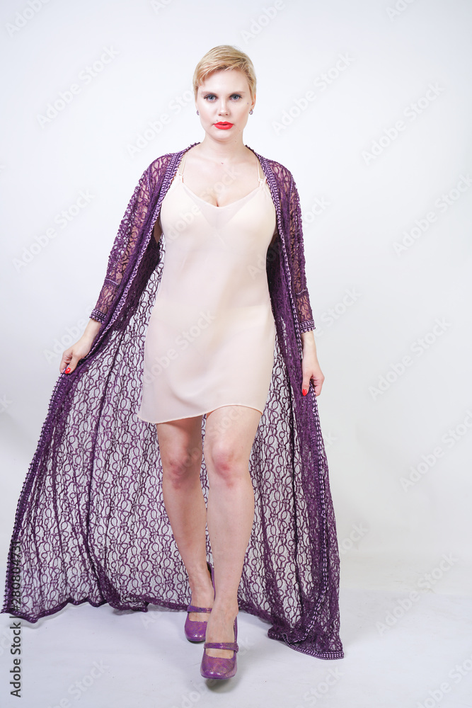 Φωτογραφία Beautiful woman in purple lace robe on white studio background alone standing